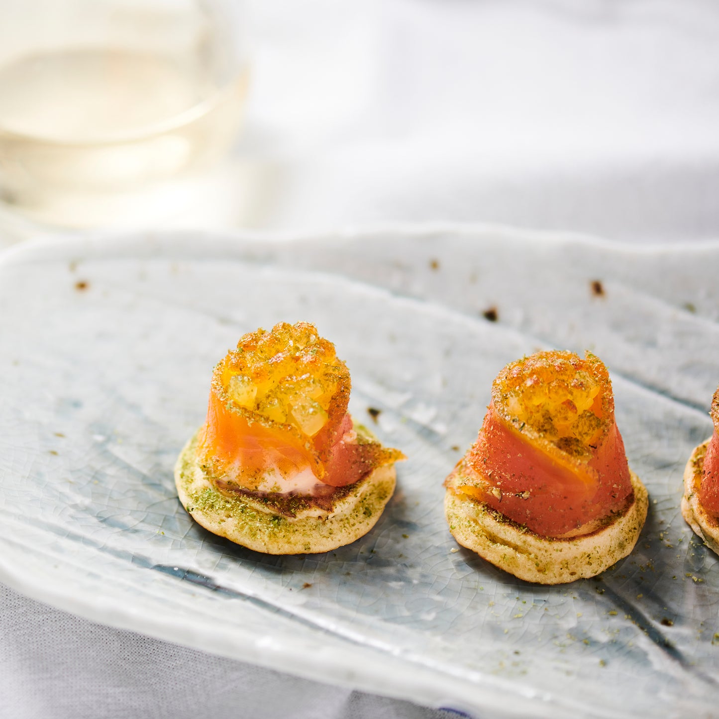 SALMON BLINI, CULTURED CREAM, PICKLED SHALLOTS, DILL. (40)
