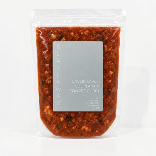 A clear stand-up pouch containing with BLAKEAWAY's cauliflower, eggplant and tomato curry with a label on the front that reads 1g, dairy free, gluten free, vegetarian and vegan.