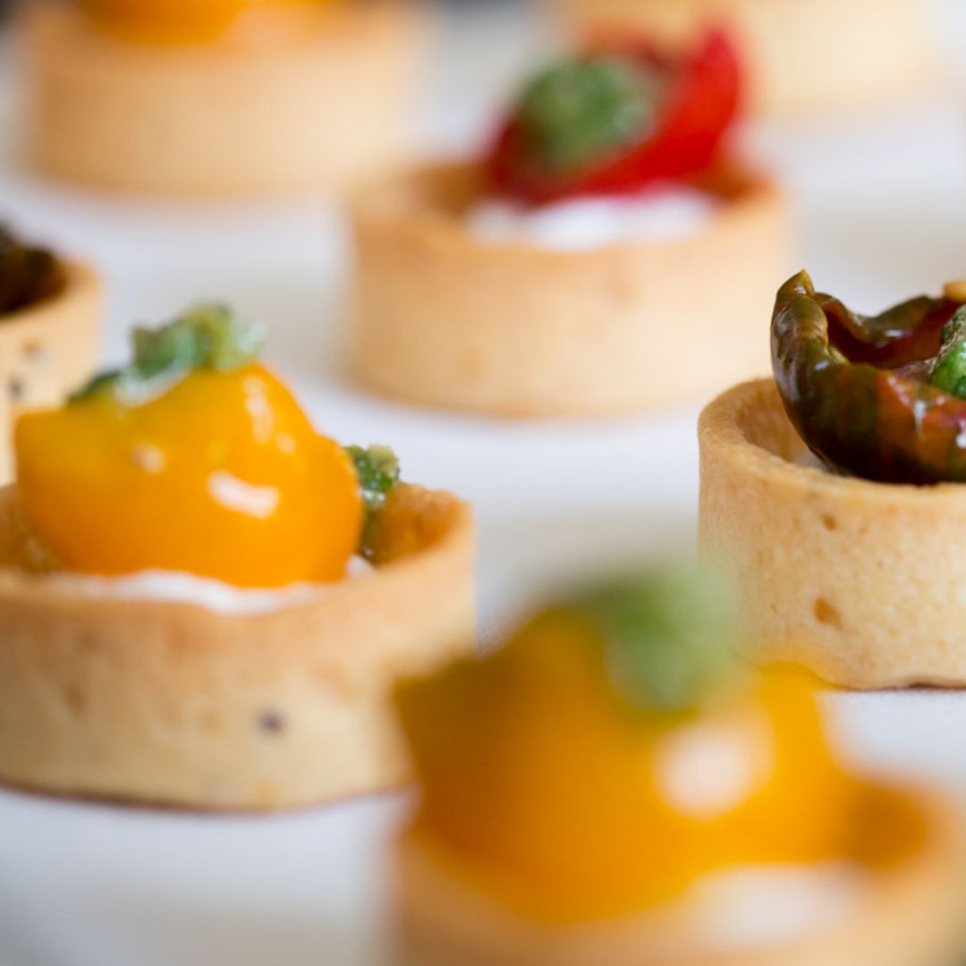 Small canape tartlets with heirloom tomatos, goats curd and salsa verde