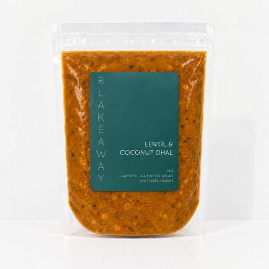 A clear stand-up pouch of BLAKEAWAY's Lentil & Coconut Dhal containing an orange-brown lentil sauce, with a dark teal label on the front, set against a plain white background.
