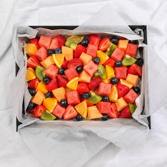 Assorted fruit salad in a box on a white background