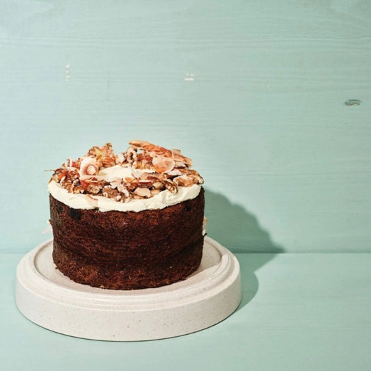 Carrot cake with white frosting on a light blue background