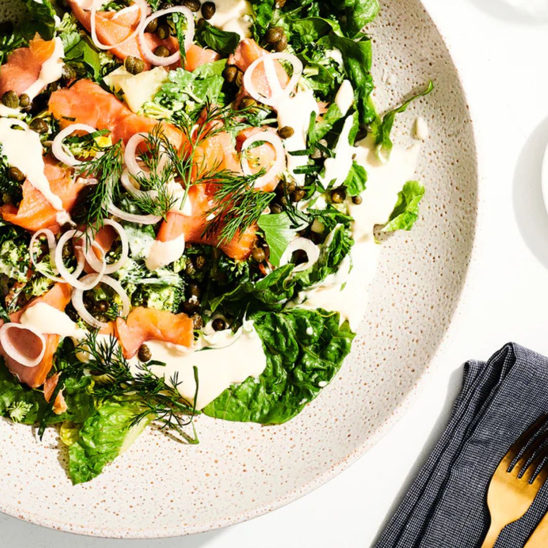 A plate of house-smoked salmon, kipfler potato, cornichon, and leaf salad with seed-mustard vinaigrette.