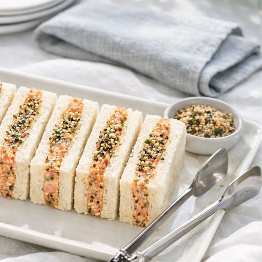 Plated sandwiches with a side of condiment on a light surface