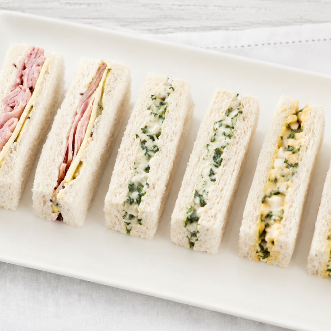 Plated assortment of mixed finger sandwiches on a white plate