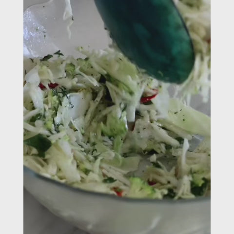 Cabbage & Broccoli Slaw, Parmesan, Toasted Pine Nuts & Lemon Vinaigrette being served with chicken schnitzels