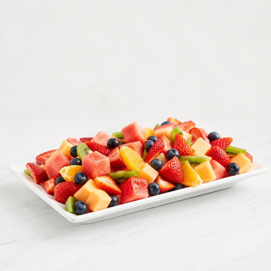 Assorted fruit salad on a white plate with a white background