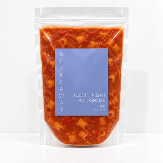 A clear stand-up pouch containing cooked pasta and red sauce, with a large blue label reading 'BLAKEYAWAY' and 'TUBETTI RIGATI BOLOGNAISE 1 KG'.